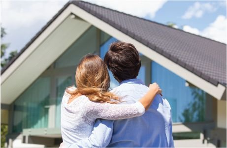 A couple stands, admiring house.