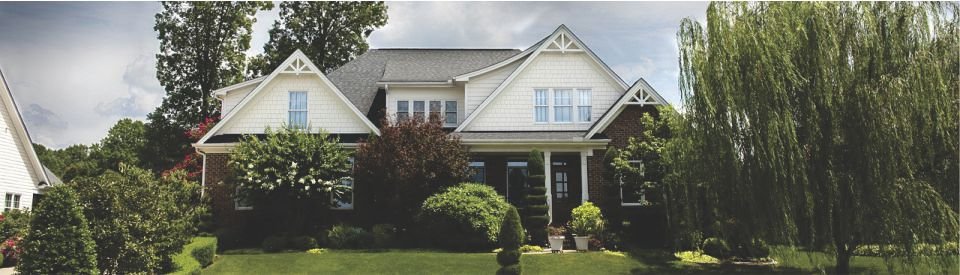 A charming suburban house with a gray roof and white facade.